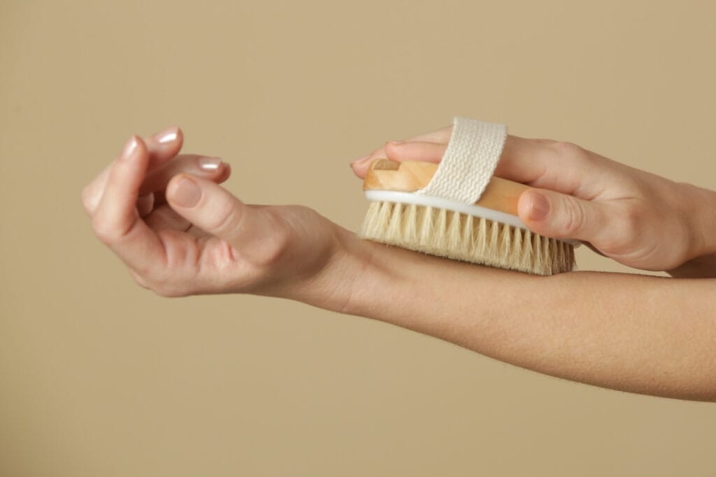 young white lady dry brushing her skin