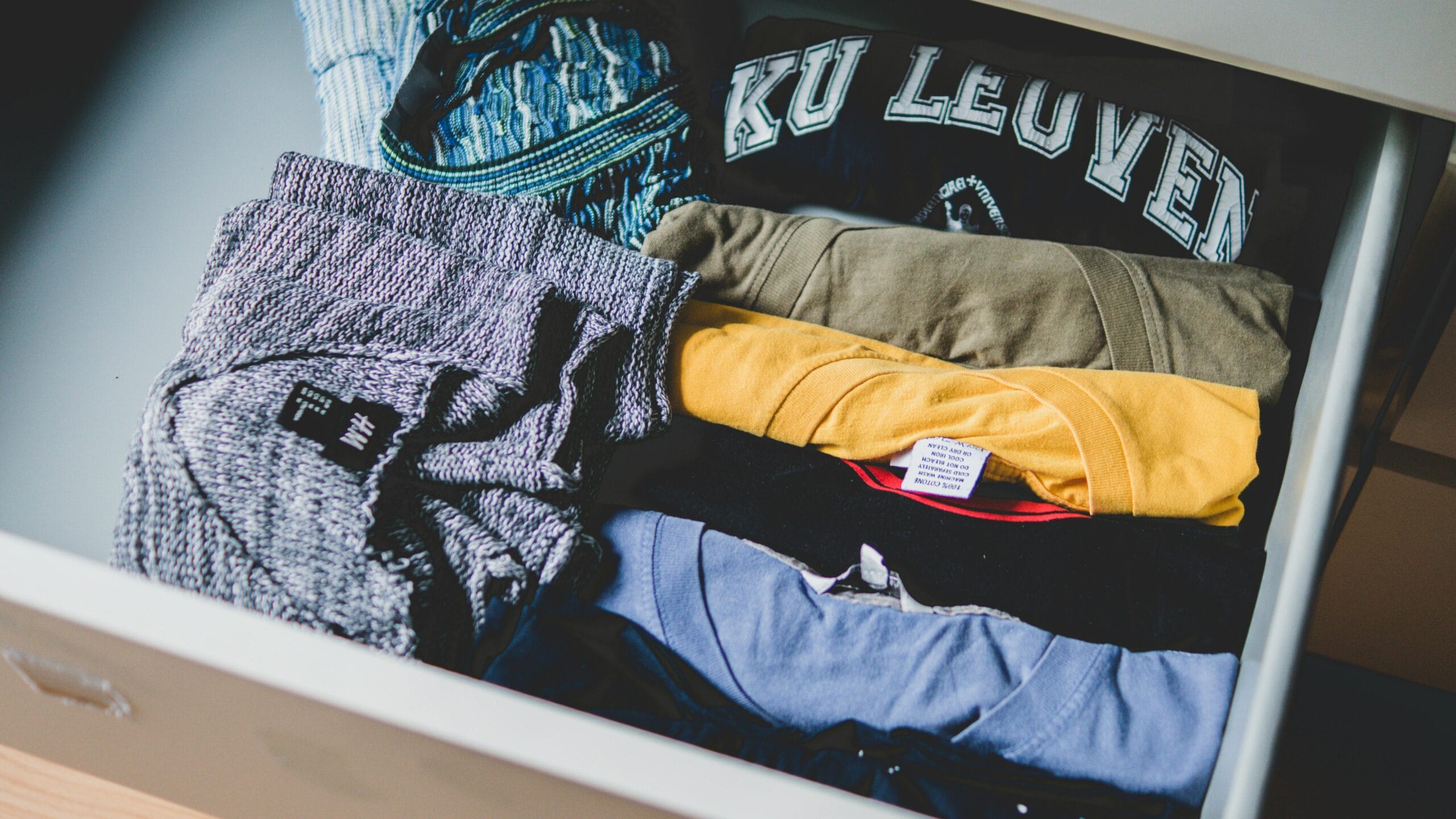 Drawer with clothes A neat arrangement of clothes and T-shirts in a drawer, showcasing casual wear.