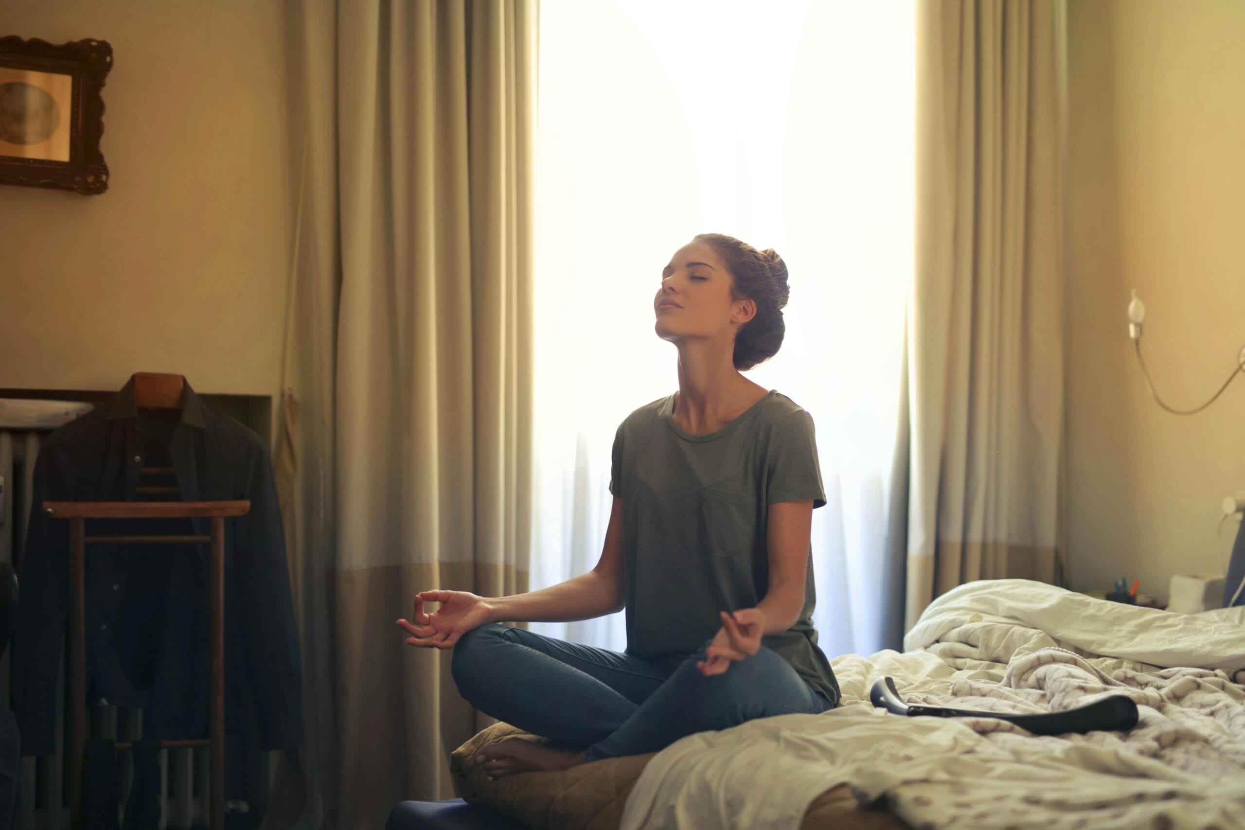 pexels photo 3772612 3772612 Adult woman practicing meditation on her bed surrounded by a calm bedroom atmosphere.